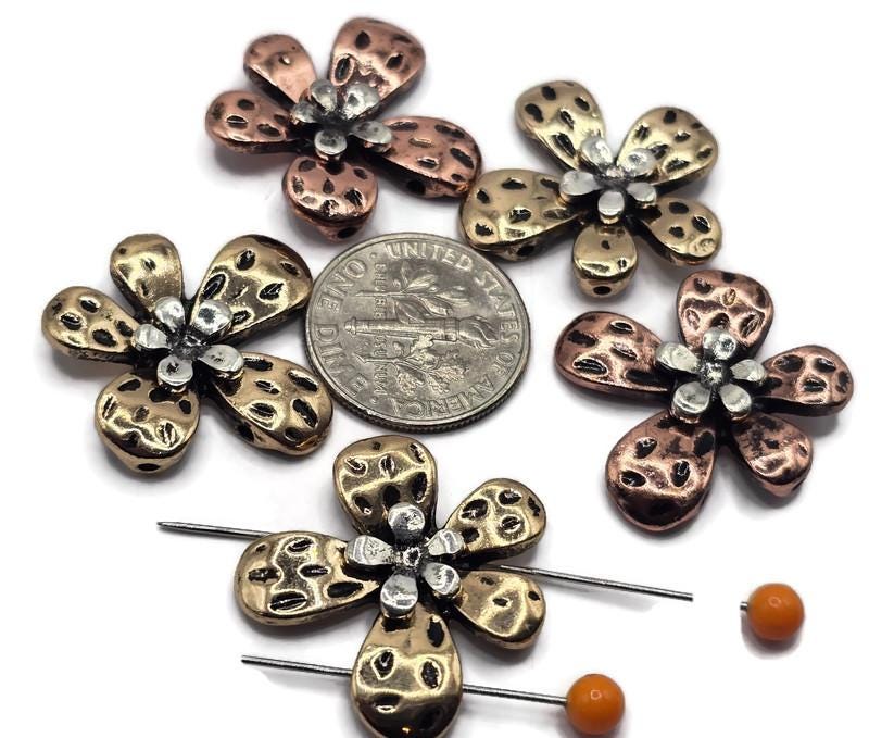 These 2-hole metal slider beads in a flower shape are perfect for adding a touch of nature and elegance to your jewelry designs.