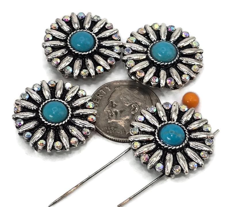 These round 2 hole slider beads feature a radiant floral burst design highlighted by a turquoise cabochon center and halo of rainbow rhinestones. Their two-hole construction ensures stability and flat placement in your jewelry projects, perfect for bracelets, chokers, and pendants. Measuring close to a dime in size, they make dramatic focal beads or decorative accents in bohemian, Southwestern, and festival-inspired jewelry.
