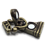 An antique bronze metal clasp or latch component with magnet inserts, shown on a plain white background.