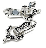 Bright silver fold over magnetic clasp with decorative black enamel scroll patterns and a secure hinged closure mechanism. The clasp is photographed open and closed to show how the magnetic system operates. Featuring one loop on each end for easy attachment to bracelet designs, this jewelry finding is ideal for handmade bracelets, beading wire projects, artisan accessories, and custom jewelry creations.