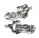 Ornamental silver magnetic clasp with black enamel detailing and a fold over hinged design for added bracelet security. The polished finish and decorative scroll motif create a sophisticated appearance suitable for many jewelry styles. Featuring attachment loops at both ends, this single-strand clasp is perfect for handmade bracelets, artisan jewelry, magnetic closures, and jewelry making supplies.