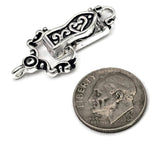 Ornate silver fold over magnetic bracelet clasp accented with black enamel scrollwork and decorative vintage-inspired details. The hinged design folds securely over the magnetic base while maintaining an elegant appearance. Featuring a single loop on both ends, this clasp is suitable for handmade bracelets, artisan jewelry, leather accessories, magnetic closures, and jewelry making supplies.
