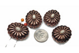 Four copper colored metal buttons with a white oval center. The buttons have a raised design that resembles a flower. The buttons are arranged in a semi-circle with a US dime in the center for size comparison.