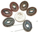 Add bold texture to your handmade designs with these oval 2-hole slider beads. Featuring mixed metal finishes in antique silver, copper, and bronze, these artisan beads have a woven-style raised pattern around an open center. Their dual-hole construction ensures durability and balance in chokers, bracelets, and necklaces. Perfect for boho festival jewelry, rustic artisan collections, or Southwestern-themed designs with natural flair.