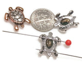 Mixed‑metal 2‑hole slider beads featuring adorable sea turtles with raised shells and metallic contrast. Secure double‑hole threading ensures easy alignment in bracelets and chokers. Perfect as focal or spacer beads in boho, coastal, or travel‑inspired jewelry lines representing balance and gentle strength.
