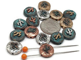 Cactus coin slider beads with weathered surfaces and sculpted saguaro icons. Two-hole construction, mixed-metal finishes—silver, copper, brass, and teal patina. Ideal focal beads for bracelets or pendant centers on necklaces. SEO phrases: cactus charm bead, southwest bead, desert jewelry supplies, western beads, round metal slider bead, patina cactus bead.