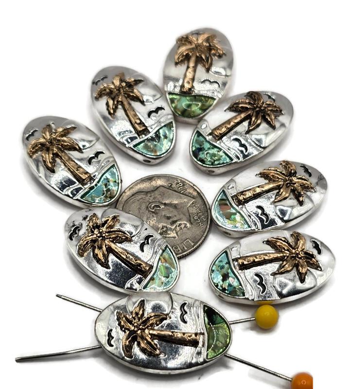 Bring tropical vibes to your jewelry designs with these stunning palm tree slider beads. Each bead features a raised golden palm tree against silver with ocean waves and a shimmering abalone inlay. The two-hole slider design makes them secure in multi-strand bracelets, necklaces, and anklets. Perfect for beach-themed jewelry, vacation gifts, and bohemian coastal collections.