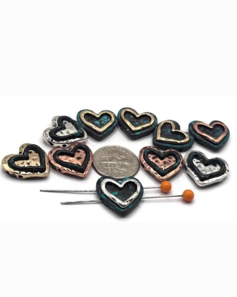These rustic heart slider beads bring artisan charm to your jewelry designs. Made in antique silver, bronze, and copper with distressed patina accents, each 2-hole bead has a raised open-heart design. Perfect for chokers, multi-strand bracelets, or romantic necklaces, their dual-hole structure ensures durability and balance. Great for boho, woodland, and symbolic jewelry celebrating love, connection, and handmade style.