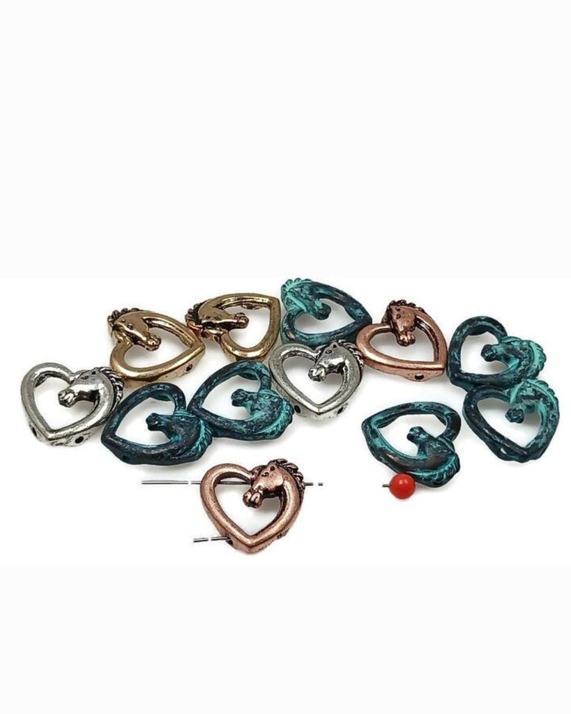 These horse head heart slider beads are perfect for equestrian-inspired jewelry. Made in antique silver, bronze, copper, and turquoise patina finishes, each 2-hole bead features an open heart with a detailed horse motif. The dual-hole design ensures balance and stability for chokers, bracelets, and necklaces. Ideal for Western, boho, or symbolic jewelry that celebrates love, freedom, and the beauty of horses.
