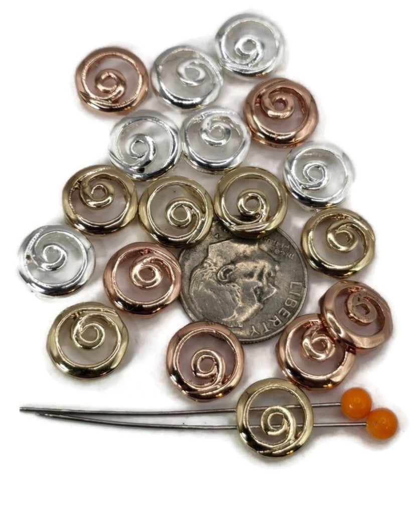 These round swirl 2 hole slider beads feature a simple yet elegant spiral design in mixed metallic finishes of silver, gold, and copper. Their two-hole construction allows these beads to sit flat and secure, making them ideal as focal beads for bracelets, pendants, and necklaces or as spacer beads in multi-strand jewelry. Crafted from durable metal alloy, they offer both style and function.