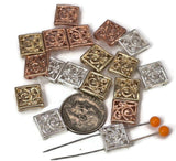 Square filigree 2 hole slider beads in mixed finishes of silver, gold, and copper. Each bead features a swirling floral scroll design, making them elegant focal beads for necklaces, bracelets, and pendants. Their two-hole construction ensures a flat, secure fit, perfect for boho, vintage, or modern handmade jewelry projects.