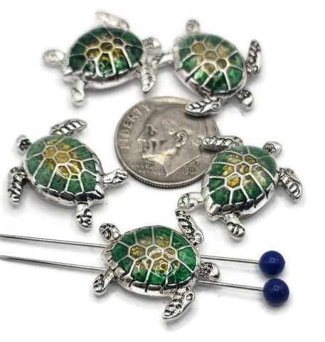 These sea turtle slider beads are perfect for coastal-inspired jewelry designs. Each bead features a silver-tone frame with a vibrant green and yellow enameled shell, capturing the beauty of the ocean. The dual 2-hole slider construction ensures strands remain flat and secure, making them ideal for chokers, bracelets, and necklaces. Perfect for boho artisans, nautical jewelry, and handmade gifts for beach lovers.
