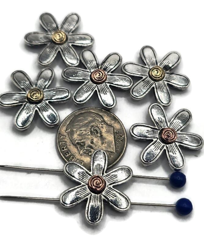 These daisy flower slider beads add a cheerful, rustic touch to handmade jewelry. Each bead features detailed silver petals with a spiral center in gold or copper tone, creating a unique artisan look. Perfect for threading onto wire, cord, or beaded strands, they are ideal for bracelets, necklaces, and DIY crafts. Durable and versatile, they bring timeless floral charm to your jewelry designs.
