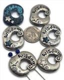 These mixed‑metal donut sliders feature embossed lettering and rhinestone details for a meaningful shine. Use in double‑strand bracelets, layered chokers, or pendant bars. Their dimensional design catches light beautifully, making them stand out as centerpiece beads or unique spacer bars in boho, zen, or spiritual jewelry.