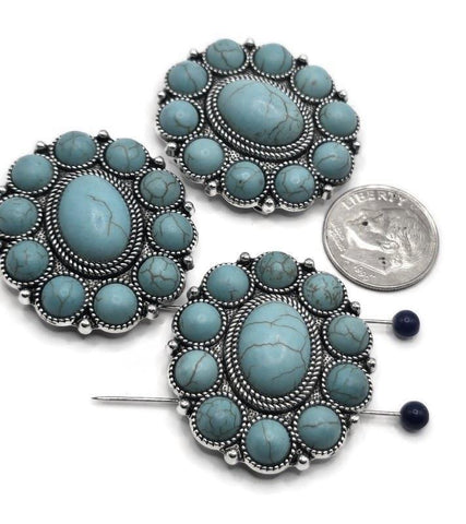 Bring vibrant Southwestern style to your jewelry with these turquoise oval slider beads. Featuring a large faux turquoise cabochon surrounded by smaller accent stones in an ornate silver frame, these dual-hole sliders provide stability and symmetry. Perfect as bracelet, choker, or necklace focals, they add artisan character to boho, rustic, or Western-inspired jewelry designs. Durable, eye-catching, and symbolic.