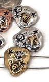 Craft meaningful beach jewelry with these seashell slider beads. Each bead features detailed ocean motifs, including raised scallop shells, spirals, and stars, on a stone‑like base. Available in mixed antique finishes of brass, copper, and silver, their dual holes keep them secure in bracelets or pendants. Perfect artisan focals for nautical, bohemian, or summer jewelry collections full of seaside charm.