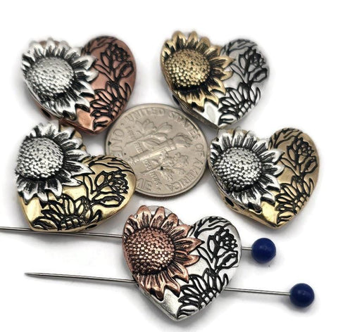 These sunflower heart-shaped slider beads are perfect for statement focal jewelry. Crafted with exquisite sunflower detail and floral accents, they’re available in antique copper, silver, and brass finishes designed not to tarnish. Dual holes ensure stability in multi-strand designs, making them versatile for bracelets or pendants. Great for artisan floral jewelry, rustic gifts, or bohemian collections celebrating nature’s beauty.