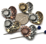 Bring warmth and beauty to handmade jewelry with these sunflower heart-shaped slider beads. Crafted in antique copper, silver, and brass tones with non‑tarnish finishes, each bead showcases a raised sunflower against floral detailing. With two alignment holes, they sit securely as pendants or focal beads in necklace and bracelet designs. Perfect artisan supplies for floral, boho, or rustic jewelry.