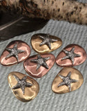 These starfish 2‑hole slider beads capture the charm of the sea. Each pebble‑shaped bead features a raised silver starfish against warm antique brass or copper finishes. Dual holes keep them secure, making them perfect focals for bracelets or pendants. Artisan‑style and coastal‑inspired, they’re great for handmade nautical jewelry, bohemian collections, or summer gifts celebrating oceanside beauty.