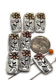 These rectangular 2 hole slider beads feature a raised daisy flower in copper or gold against an antique silver base with engraved vines. Their two-hole slider layout ensures the beads stay flat and balanced, making them perfect for bracelets, necklaces, or chokers. With rustic charm and floral beauty, they work well as focal beads or decorative spacers in handmade, bohemian, or garden-inspired jewelry. Durable metal alloy construction makes them a must-have DIY jewelry finding.