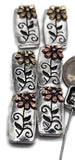 These antique silver rectangular slider beads feature dimensional daisies in gold and copper finishes, accented by scrolling vine engravings. Designed with two stringing holes, they sit flat in jewelry, making them excellent for bracelets, chokers, or multi-strand necklaces. Their natural flower design makes them perfect for bohemian, rustic, or garden-inspired jewelry projects.
