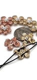 These metal flower beads are designed as 2 hole sliders with hammered-effect petals in warm copper and rustic gold. Accented with silver-toned centers, they offer rustic yet elegant detail for jewelry. Their two-hole format ensures flat placement, making them ideal focal beads or spacers in boho bracelets, floral chokers, and artisan necklaces.