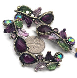 These botanical 2‑hole slider beads feature faceted resin teardrops in deep plum, accented with Austrian crystals and rhinestones. Antique brass/gold settings wind into leafy vines with hand‑tinted enamel leaves in lavender and green. Dual holes keep the focal flat for bracelets, chokers, or pendant bars. Perfect for boho luxe, cottagecore, and Art Nouveau jewelry needing romantic color and secure alignment.