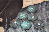 These turquoise flower slider beads bring instant pop to handmade designs. Textured petals and a crystal center add shimmer and depth, while the dual holes keep beads aligned and stable. Ideal as focal beads in leather-wrap bracelets, chokers, or pendants, they pair beautifully with silver, copper, or gemstone accents. Great for bohemian, Western, and summer jewelry collections. Durable alloy construction with patina finish.