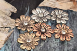 These inspirational daisy slider beads bring shine and sentiment to handmade jewelry. Each metal flower has words etched on every petal and a faceted rhinestone center. Two stringing holes keep the bead flat for a polished, professional look in bracelets and chokers. Use as focal beads in giftable pieces for graduations, encouragement, or daily affirmations. Mix with leather, gemstones, or seed beads.