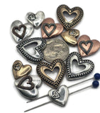 These rustic 2-hole heart slider beads are ideal for boho and romantic jewelry. Available in antique silver, bronze, and copper finishes, the designs include solid puffed, open, and layered double hearts. With a dual-hole slider construction, they stay secure and flat in bracelets, chokers, and necklaces. Perfect for Valentine’s jewelry, symbolic handmade gifts, and artisan accessories celebrating love.