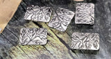 Nature rectangle beads with embossed tree branch/leaf pattern. These 2‑hole sliders have small parallel holes for fine stringing—beading wire, nylon thread, micro cord. Avoid leather/chain. Use as focal sliders or flat spacers in botanical bracelets and layered necklaces. Bright antique silver finish resists tarnish. Pack of 5 woodland plant beads.
