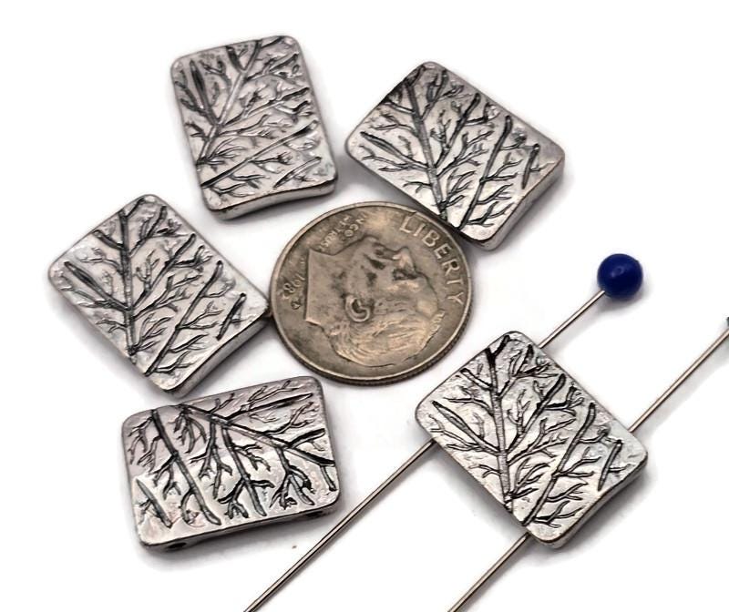 Silver metal 2 hole slider beads with etched tree branch design. Rectangular artisan beads that sit flat as focal beads in bracelets and chokers. Small, parallel holes fit fine beading wire, FireLine, Power Pro, or micro cord up to ~0.8 mm; not for leather. Lightweight, tarnish‑resistant finish. Set of 5 nature beads for woodland, cottagecore, and minimalist jewelry making.
