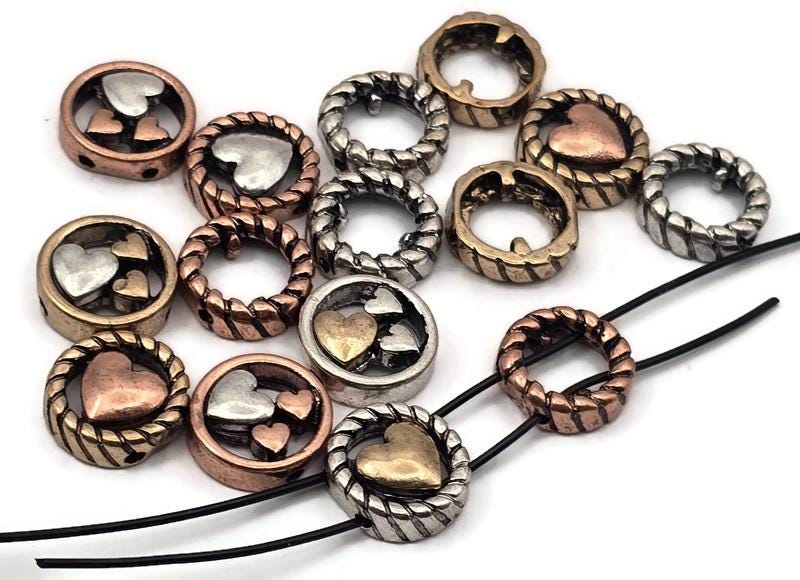 Mixed‑metal heart 2 hole slider beads that instantly become focal beads in artisan jewelry. Each round metal bead features a rope‑edge frame with raised hearts for rich dimension. Unique beads and premium metal findings that photograph beautifully for Etsy and eBay. Lead‑ and nickel‑free with a durable, anti‑tarnish finish. Assorted silver, gold, and copper tones add warm contrast to bracelets, chokers, and pendant designs.