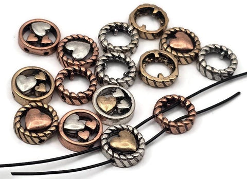 Mixed‑metal heart 2 hole slider beads that instantly become focal beads in artisan jewelry. Each round metal bead features a rope‑edge frame with raised hearts for rich dimension. Unique beads and premium metal findings that photograph beautifully for Etsy and eBay. Lead‑ and nickel‑free with a durable, anti‑tarnish finish. Assorted silver, gold, and copper tones add warm contrast to bracelets, chokers, and pendant designs.