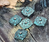 Make your listings pop with verdigris patina slider beads. The soft square silhouette, embossed floral star, and crystal center catch light from every angle. Two-hole construction helps the component sit neat and centered. These metal beads bring instant boutique energy to artisan bracelets, chokers, and pendants. Each bead has intentional color variation for a one‑of‑a‑kind look buyers love.