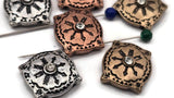 These ornate metal beads bring Renaissance-inspired detail to your collection. The raised sun motif radiates around a clear crystal, framed by patterned borders and a cushion-square silhouette. Crafted as 2 hole slider beads, they sit beautifully in finished pieces and photograph with eye-catching contrast. Choose from antique silver, copper, or brass tones. High-quality metal findings and unique beads for standout focal designs.