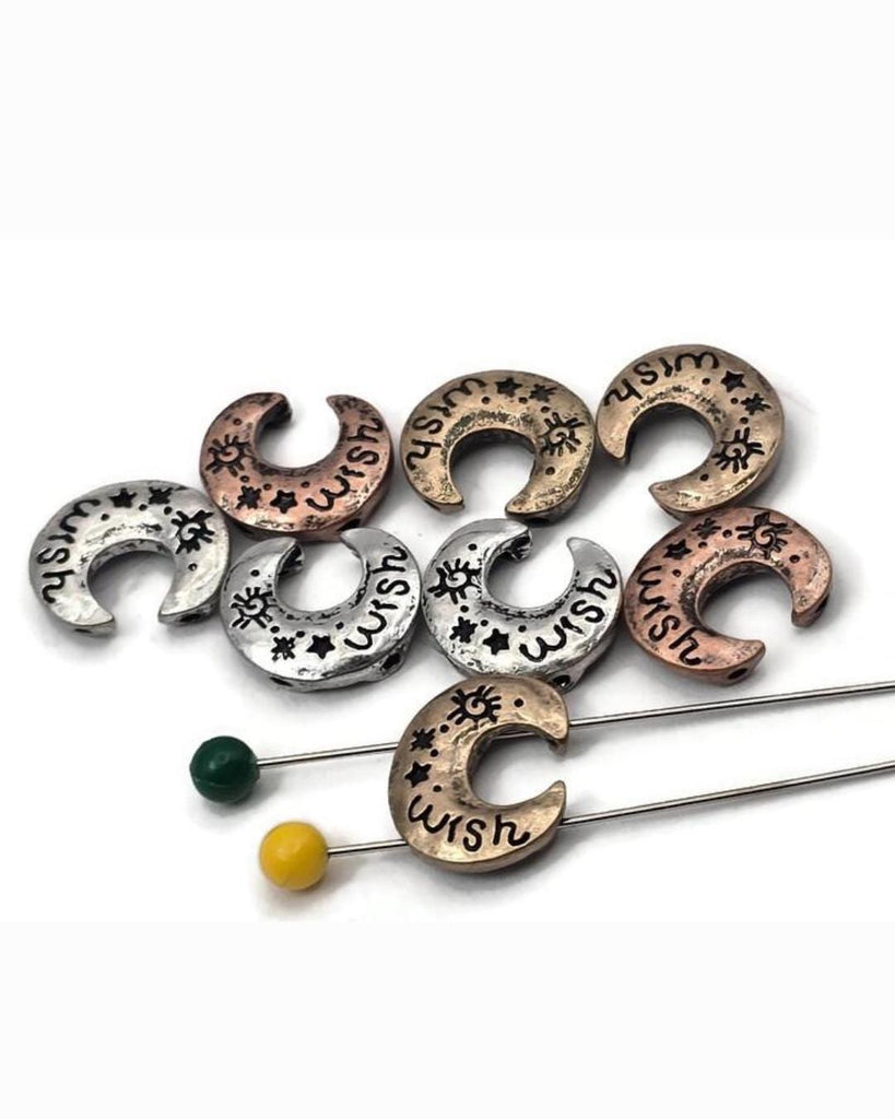 Crescent “wish” 2 hole slider beads designed to add a touch of magic. Engraved stars and lettering wrap the curve, while antiqued silver, copper, and brass finishes emphasize texture. These unique beads serve beautifully as focal beads for bracelet designs and pendant centers on necklaces. A versatile celestial component with timeless appeal.