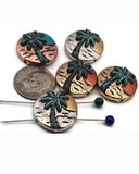 Palm tree sunset beads, 2 hole slider style, in mixed metal finishes. Round coin shape with raised tropical palm, ocean waves, and sun detail. Colors include antique silver, warm copper, and vintage brass with teal patina accents. Great focal beads for bracelet designs and pendants on necklaces. Keywords: beach bead, tropical bead, palm tree bead, sunset bead, coastal jewelry supplies.