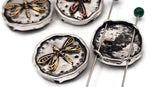 Nature-inspired dragonfly beads for jewelry making. Two-hole coin sliders with dimensional dragonflies and oxidized backgrounds. Antique silver with copper/brass accents for vintage charm. Ideal focal beads for bracelets and necklaces. Search terms: dragonfly charm bead, insect focal, mixed metal bead, rustic coin bead, woodland jewelry supplies.