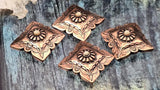 Copper concho slider beads with scalloped edges and stamped floral detailing. Raised rosette center with pale cabochon adds vintage saddle style. Two-hole construction keeps the square concho centered. Ideal focal beads for bracelets and pendant necklaces. Search terms: square concho bead, western focal bead, cowboy cowgirl jewelry, copper slider bead.