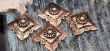 Statement concho coin sliders in antique copper with floral center and scalloped frame. Cream cabochon accent, engraved border, and hammered texture for authentic tack-inspired style. Two-hole design keeps everything aligned. Ideal focal beads for bracelet builds and pendant features. Keywords: square concho focal, copper western bead, boho cowgirl bead, metal slider component.