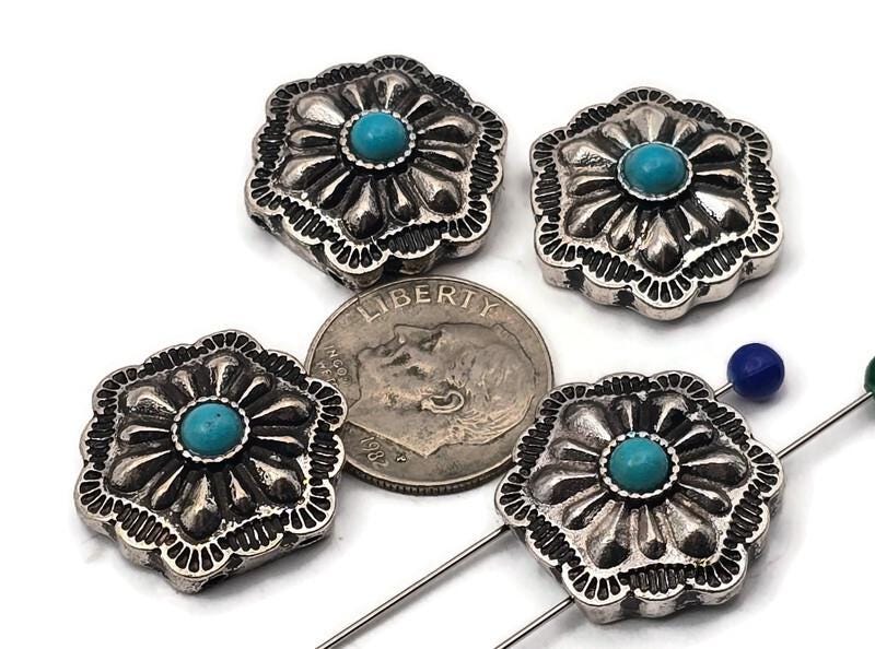 Antique silver concho beads with turquoise center cabochon. These 2 hole slider beads feature a scalloped square concho shape with deep floral stamping and dotted bezel. Ideal focal beads for bracelet designs and pendant centers on necklaces. Keywords: turquoise concho bead, western jewelry supplies, silver concho slider, boho southwestern bead, metal focal bead, 2 hole bead.