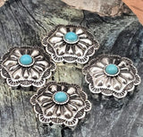 Southwestern turquoise concho slider beads in vintage silver. The sculpted flower petals and scalloped edges create bold dimension, while the sky-blue cabochon delivers classic western color. Two parallel holes keep the concho centered. Perfect focal beads for bracelets and necklaces. Keywords: concho bead for bracelet, turquoise centerpiece bead, silver western bead, cowboy cowgirl jewelry components.