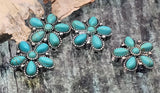 Antique silver turquoise blossom sliders with dotted concho detail. The flower silhouette combines teardrop petals and a domed center for sculpted depth. These 2 hole slider beads create a polished focal bead for bracelets and a bold pendant for necklaces. Perfect for western fashion, festival outfits, and southwest jewelry themes.