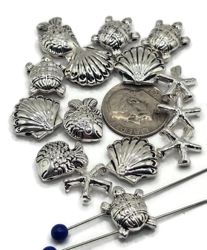 These ocean slider beads bring coastal magic to handmade jewelry. Featuring sea turtles, fish, seashells, and starfish in antique silver, their detailed raised designs add charm to necklaces, chokers, and bracelets. With 2-hole slider construction, strands remain flat, secure, and balanced. Perfect for boho designs, nautical jewelry, or unique handmade gifts inspired by the sea.