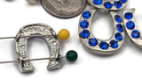 Sapphire blue crystal horseshoe sliders—perfect lucky charms for everyday stacks. Silver metal with small parallel holes for fine stringing materials; not compatible with leather or chain. Use as statement focals in bracelets and pendant necklaces or as bold earring components. Set of five glittering beads.
