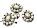 Add character and structure to your jewelry with these oval two hole slider beads. Each bead features a central faux white howlite stone surrounded by matching cabochons in a detailed silver-tone frame. The dual-hole design keeps them aligned in multi-strand designs, making them perfect focal accents for bracelets, chokers, or statement necklaces with artisan or bohemian themes.