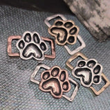 These paw print two‑hole slider beads are the perfect focal pieces for animal and pet‑inspired jewelry. Each bead showcases raised paw detail in antique silver, copper, and brass finishes, accented with dimensional texture for added charm. Dual holes make them secure in multi‑strand projects, ideal for bracelets, chokers, or necklaces. Great supplies for memorial jewelry or gifts for pet owners.
