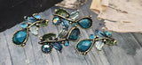 These luxurious teal glass 2‑hole slider beads showcase pear‑cut crystals, petite rounds, and painted leaves on antique brass branches. Dual holes provide secure alignment in multi‑strand bracelets, collars, and chokers. Perfect for boutique statement pieces, special occasion jewelry, and nature‑inspired designs with luminous color and heirloom style.