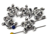 Polished silver 2‑hole turtle slider beads featuring textured shells and gently curved fins. Designed to stay flat and evenly spaced in bracelets or multi‑strand chokers. Ideal for ocean‑themed, bohemian, or mindful jewelry, these bright metallic turtles symbolize balance and steady movement through life’s journey.